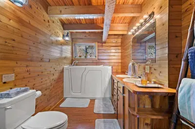 a wooden bathroom with a toilet and a sink at Fun fishing river cabin 23mi to beach with private dock 3BD 2BA in Youngstown