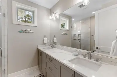 a bathroom with two sinks and a large mirror at Hidden Tides in Rosemary Beach