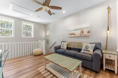 a living room with a couch and a ceiling fan at Hidden Tides in Rosemary Beach