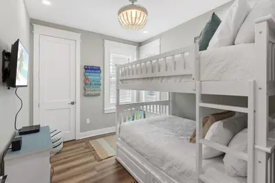 a bedroom with a white bunk bed and a desk at Hidden Tides in Rosemary Beach