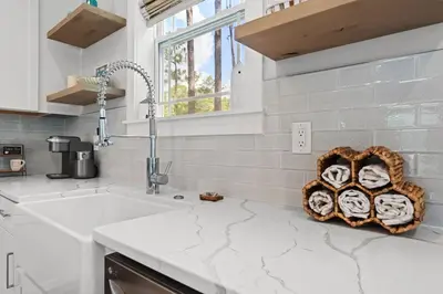 a kitchen with a white counter top with a sink at Hidden Tides in Rosemary Beach