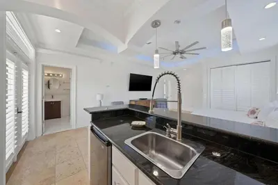 a kitchen with a sink and a bed in the background at Seacrest Getaway in Rosemary Beach