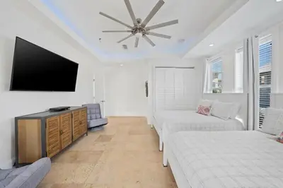a living room with a couch and a flat screen tv at Seacrest Getaway in Rosemary Beach