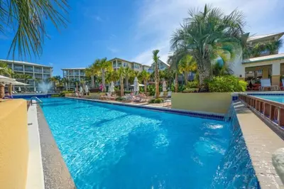 a swimming pool at a resort with palm trees at Seacrest Getaway in Rosemary Beach