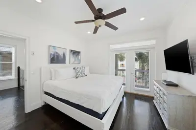 a white bedroom with a bed and a ceiling fan at Seacrest Getaway in Rosemary Beach