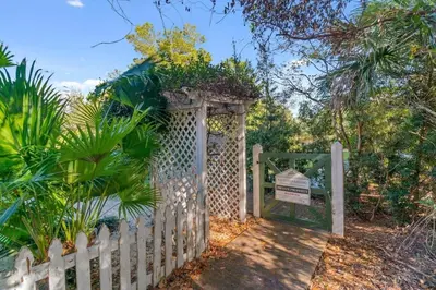 a white fence with a gate with a sign at Ocean Serenade in Rosemary Beach