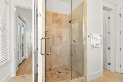 a shower with a glass door in a bathroom at Ocean Serenade in Rosemary Beach