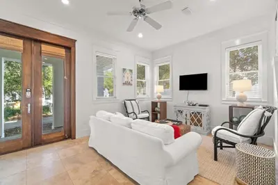 a living room with a white couch and chairs at Ocean Serenade in Rosemary Beach