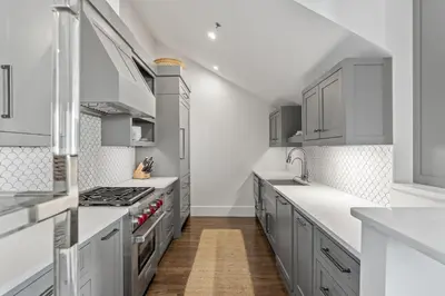 a kitchen with gray cabinets and white counter tops at The Savannah Unit 2E in Rosemary Beach