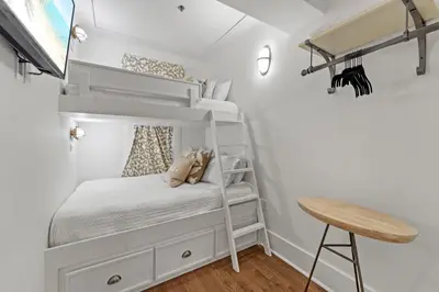 a small bedroom with bunk beds and a desk at The Savannah Unit 2E in Rosemary Beach