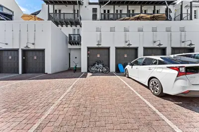 a white car parked in a parking lot in front of a building at The Savannah Unit 2E in Rosemary Beach