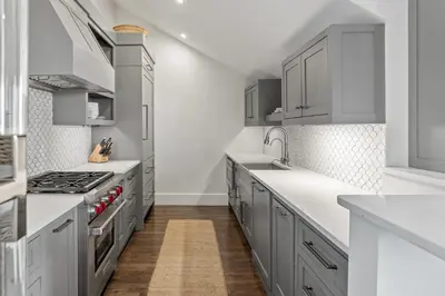a kitchen with gray cabinets and white counter tops at The Savannah Unit 2E in Rosemary Beach