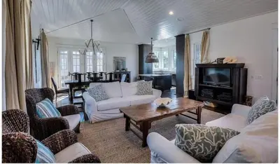 a living room with white couches and a table at Dejarnette Cottage in Rosemary Beach