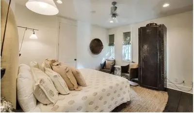 a bedroom with a bed with white sheets and pillows at Dejarnette Cottage in Rosemary Beach