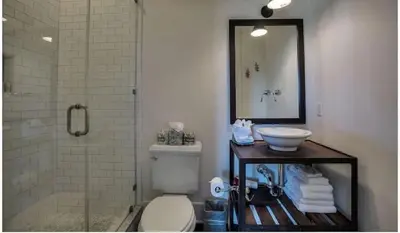 a bathroom with a toilet and a sink and a shower at Dejarnette Cottage in Rosemary Beach