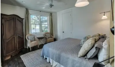 a bedroom with a bed and a dresser and a window at Dejarnette Cottage in Rosemary Beach