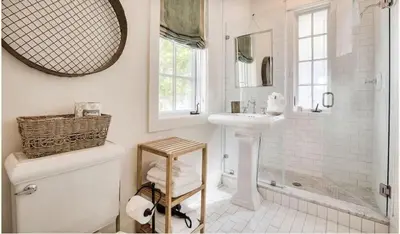 a white bathroom with a sink and a shower at Dejarnette Cottage in Rosemary Beach
