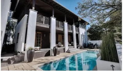 a house with a swimming pool in front of it at Dejarnette Cottage in Rosemary Beach