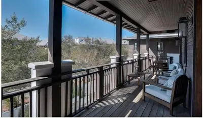 a porch with chairs and a view of the ocean at Dejarnette Cottage in Rosemary Beach