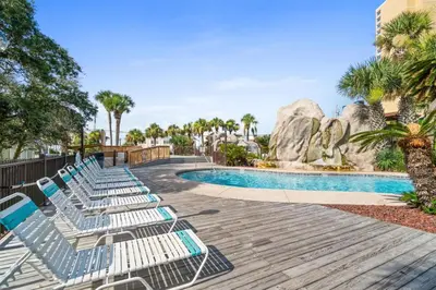 a row of lounge chairs by a pool at a resort at Portside Resort Pet Friendly Rentals by Panhandle Getaways in Panama City Beach