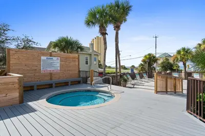 a hot tub on a wooden deck with palm trees at Portside Resort Pet Friendly Rentals by Panhandle Getaways in Panama City Beach