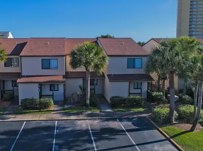 an apartment complex with palm trees and a parking lot at Portside Resort Pet Friendly Rentals by Panhandle Getaways in Panama City Beach