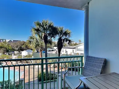 a balcony with a table and chairs and palm trees at Inn at Seacrest #203 - 30A Get-A-Way in Rosemary Beach