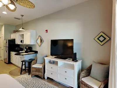 a living room with a flat screen tv and a kitchen at Inn at Seacrest #203 - 30A Get-A-Way in Rosemary Beach