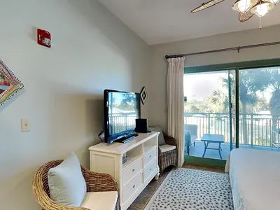 a bedroom with a tv and a bed and a balcony at Inn at Seacrest #203 - 30A Get-A-Way in Rosemary Beach