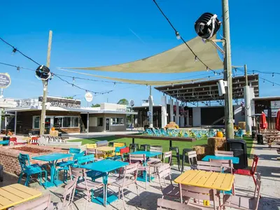 a group of tables and chairs in front of a pool at Prominence North #94A - Happy Ours in Watersound Beach
