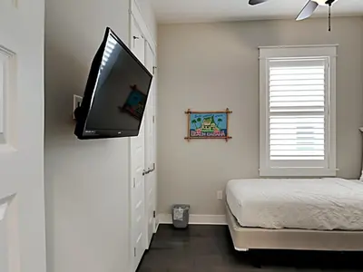 a bedroom with a bed and a flat screen tv on the wall at Prominence North #94A - Happy Ours in Watersound Beach