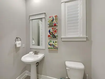 a bathroom with a sink and a toilet and a mirror at Prominence North #94A - Happy Ours in Watersound Beach
