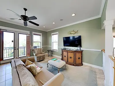 a living room with a couch and a flat screen tv at Seabreeze Cabana in Rosemary Beach