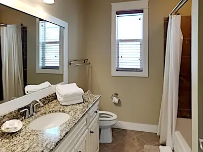 a bathroom with a sink and a toilet and a mirror at Seabreeze Cabana in Rosemary Beach