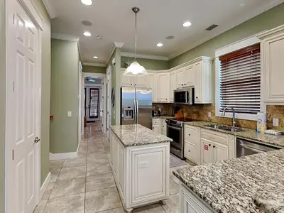 a large kitchen with white cabinets and granite counter tops at Seabreeze Cabana in Rosemary Beach