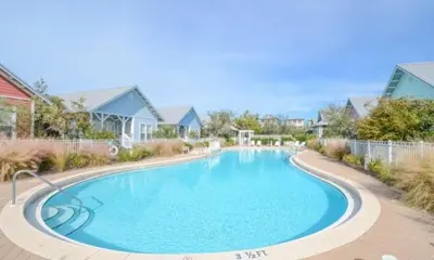a large blue swimming pool in a yard with houses at The Good Life in Seacrest