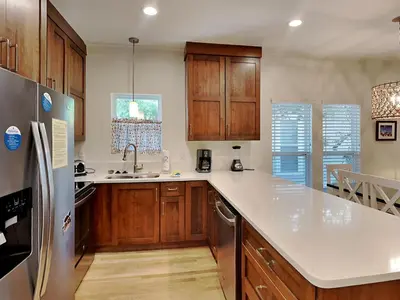 a kitchen with wooden cabinets and a stainless steel refrigerator at The Good Life in Seacrest