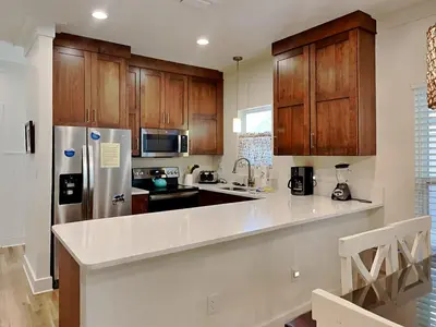 a kitchen with wooden cabinets and a refrigerator at The Good Life in Seacrest