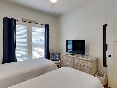 a bedroom with two beds and a flat screen tv at The Good Life in Seacrest