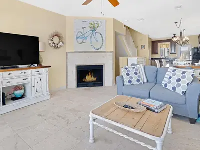 a living room with a blue couch and a fireplace at Seagrove Dunes #1 in Seagrove Beach