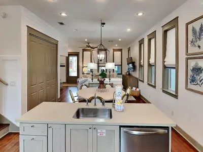 a kitchen with a sink and a living room at The Holland House II in Rosemary Beach