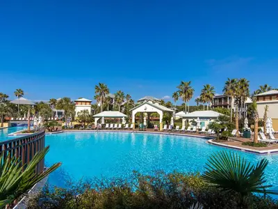 a swimming pool at a resort with palm trees at The Holland House II in Rosemary Beach