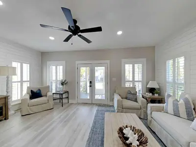 a living room with a ceiling fan and a table at Happy as a Clam in Santa Rosa Beach