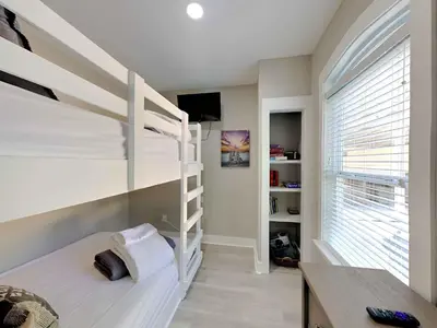 a bedroom with two bunk beds and a desk at Happy as a Clam in Santa Rosa Beach