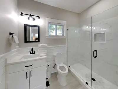 a white bathroom with a toilet and a shower at Happy as a Clam in Santa Rosa Beach