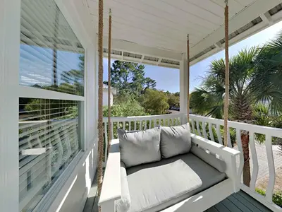 a porch with a swing on a porch at Happy as a Clam in Santa Rosa Beach
