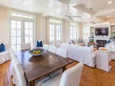 a living room with a table and white chairs at All Decked Out 30A in Seagrove Beach