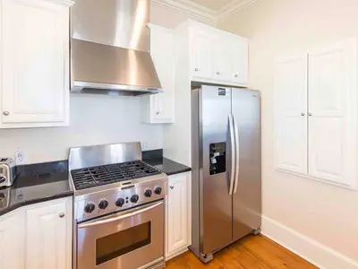 a kitchen with a stainless steel refrigerator and white cabinets at All Decked Out 30A in Seagrove Beach