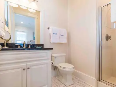 a bathroom with a toilet and a sink and a mirror at All Decked Out 30A in Seagrove Beach