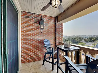 a patio with a table and chairs and a brick wall at Village Of South Walton #403E in Rosemary Beach
